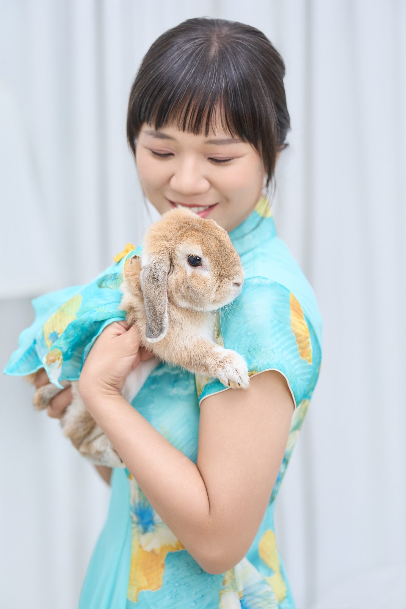 飼主溫柔抱著穿同款洋裝的兔兔